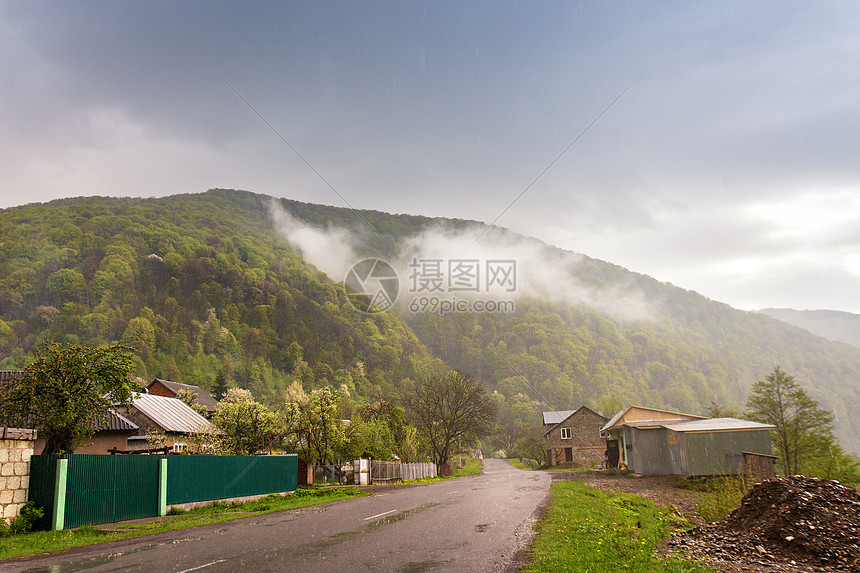 山区乡村青山谷的道路村庄春天暴风雨的雨天图片