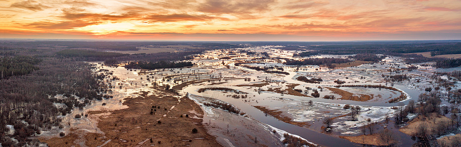 春季融化的河流洪水全景日落解冻的草地上早春时流水无人机视图图片