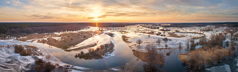 春季融化的河流洪水全景日落解冻的草地上早春时流水无人机视图图片
