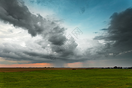 晚上的暴风雨绿色田野发电厂上空的戏剧云天空图片