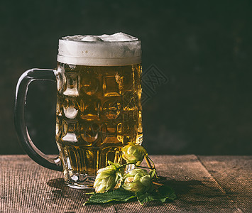 啤酒杯啤酒花黑暗的乡村桌子背景,正视图,德国风格图片