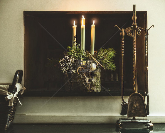 冬季舒适的家居装饰节日气氛与燃烧的蜡烛,冷杉树枝雪花壁炉客厅装饰四个降临花圈图片