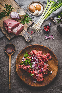 磨肉盘子与烹饪勺子与配料乡村厨房桌子背景,顶部视图图片