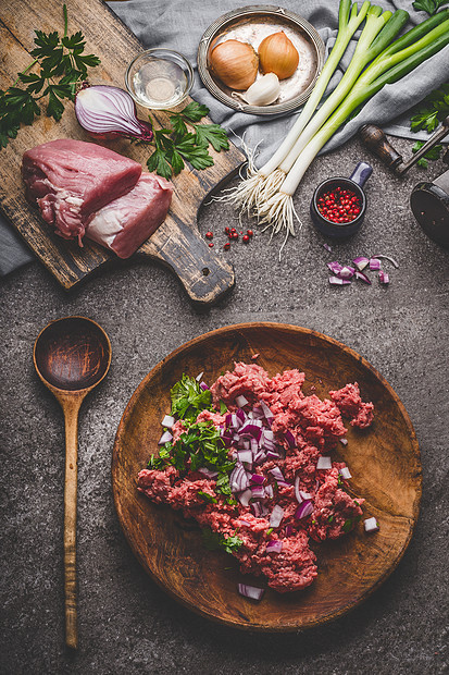 磨肉盘子与烹饪勺子与配料乡村厨房桌子背景,顶部视图图片