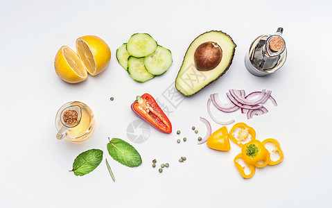 平躺新鲜沙拉蔬菜成分鳄梨,黄瓜,辣椒,洋葱,柠檬,橄榄油醋白色桌子背景,顶部视图健康的生活方式素食的饮食观念图片
