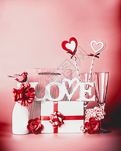情人节浪漫的静物与文字爱问候香槟,礼品盒,丝带,心装饰红色背景,正视图图片