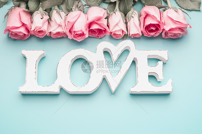白字爱情与淡粉色玫瑰绿松石蓝色背景,顶部视图现代最布局图片