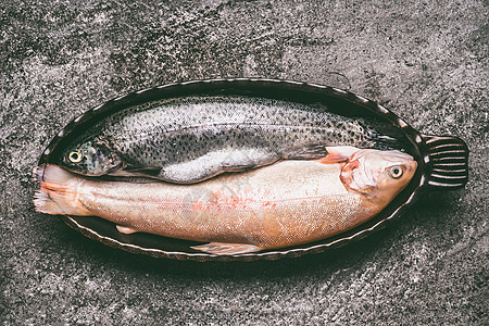 两种鳟鱼棕色鳟鱼虹鳟鱼烤碗灰色花岗岩桌子上,顶部视图健康的饮食美味的烹饪理念图片