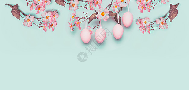 复活节横幅挂着淡粉色复活节彩蛋春天的花朵,蓝色的绿松石背景下图片