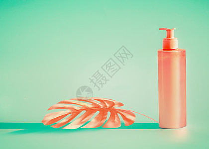 粉红色化妆瓶与配药泵热带叶薄荷背景夏季护肤防晒霜产品与的图片