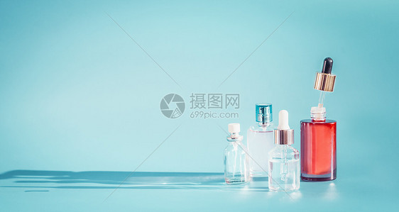 化妆品瓶产品与液体,吸管蓝色背景,正视图精华,爽肤水提取血清桌子上,正视图美容现代护肤理念与图片