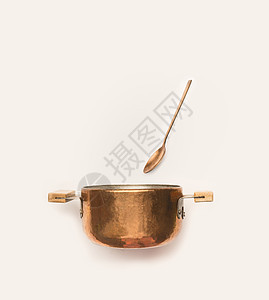 白色背景上勺子的铜锅图片