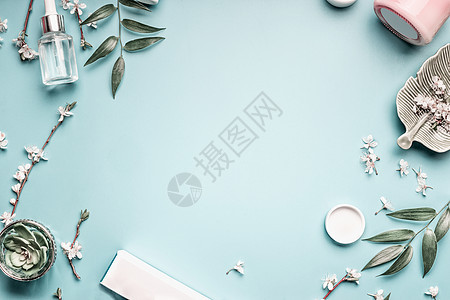 美容背景与部化妆品,树叶樱花粉彩蓝色桌背景现代春季护肤布局,俯视图,平躺图片