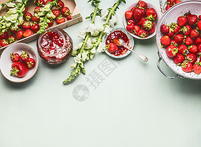 自制美味的草莓果酱璃瓶与夏季花卉新鲜浆果,碗勺子桌子背景,顶部的景观浆果保存,边界图片