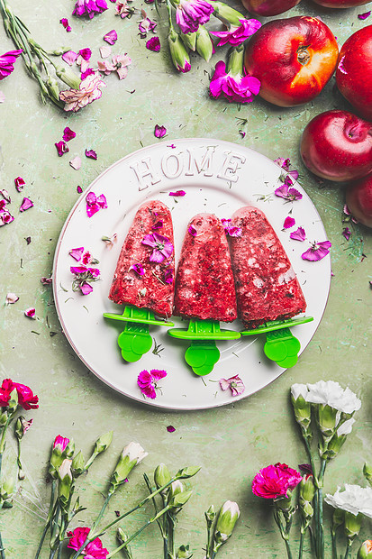 自制水果浆果冰淇淋冰棒盘子上,装饰花园花茶色乡村绿色桌子背景,顶部的景色复古风格乡村风格的夏季食物图片