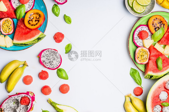 夏季清洁健康的生活方式背景与各种彩色切片热带水果浆果盘子碗白色背景,顶部视图,框架图片