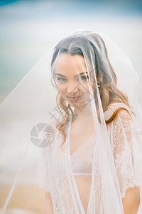 新娘纱下特写,背景蓝天黑海图片