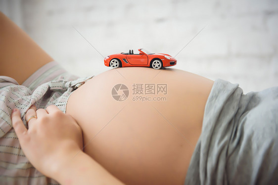 带玩具机的孕妇的中段图片