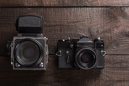 老式黑色胶卷相机棕色背景的天然木材与镜头图片