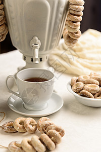 白色桌布上百吉饼热茶的萨莫瓦尔图片