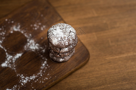 木制厨房板上糖粉的巧克力饼干图片