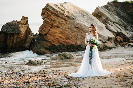 新娘夕阳的灯光下,黑海的岸边着婚礼花图片
