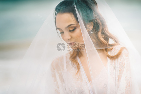 新娘纱下特写,背景蓝天黑海图片