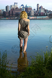 女孩晚上进入哈德逊河的背景下来曼哈顿图片