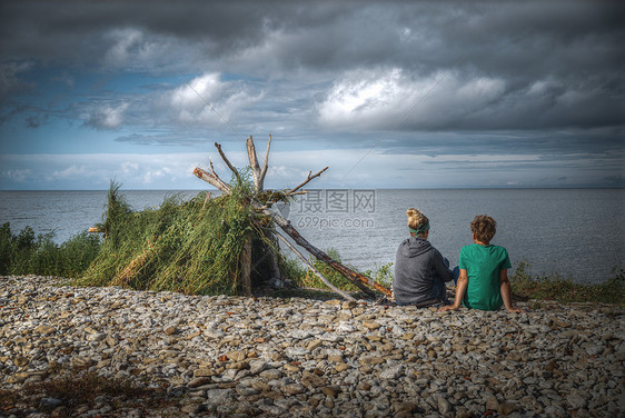 海边建了座小屋母亲儿子坐着建海边的小屋矗立着图片