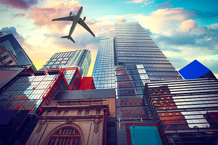 这座摩天大楼这架飞机低空飞越纽约曼哈顿天际线,usa五颜六色的日落纽约市曼哈顿天际线,usa背景