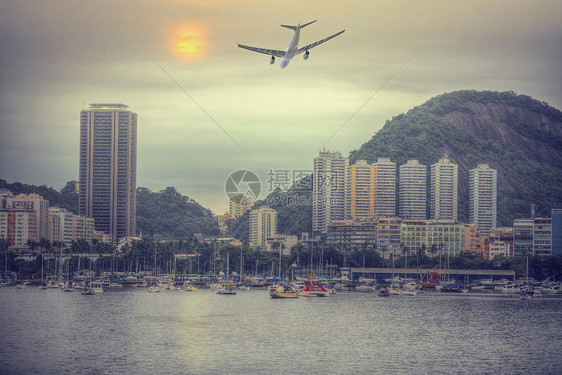 这架飞机正巴西里约热内卢上空飞行穿过海湾的城市景色图片