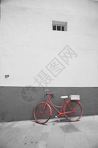 白色墙壁背景上的红色自行车黑白照片图片