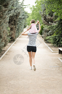 小女孩走公园里妈妈的肩膀上图片
