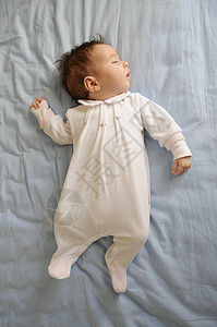 新生儿家里睡蓝色床单上图片