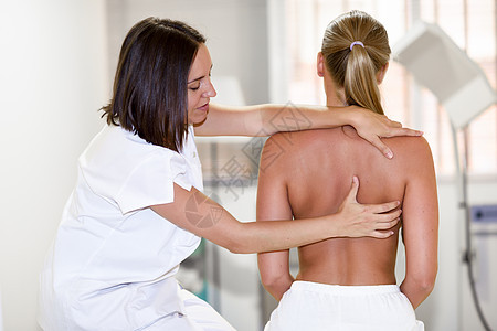 女理疗师检查她的病人理疗中心肩部的医疗检查图片