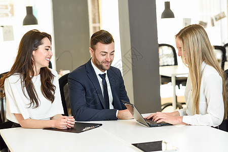 金发女人保险代理人投资顾问用笔记本电脑向微笑的轻夫妇解释图片