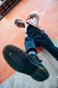 轻的黑人男子踢向地生活方式的图片