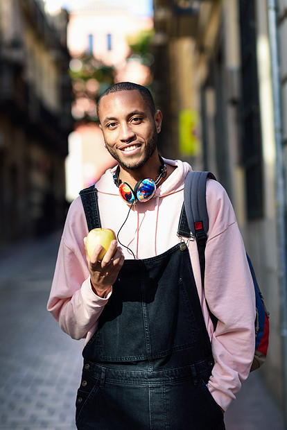 轻的黑人街上吃苹果生活方式的图片