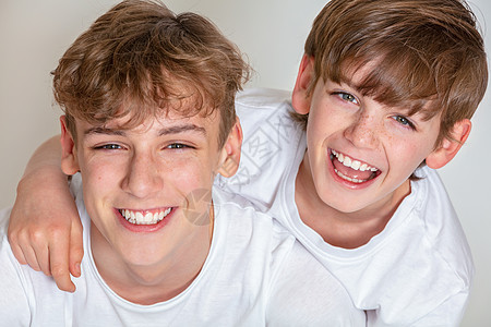白色背景工作室照片,轻快乐的男孩,孩子,兄弟微笑图片