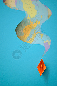 世界背景图上的纸船海浪图片