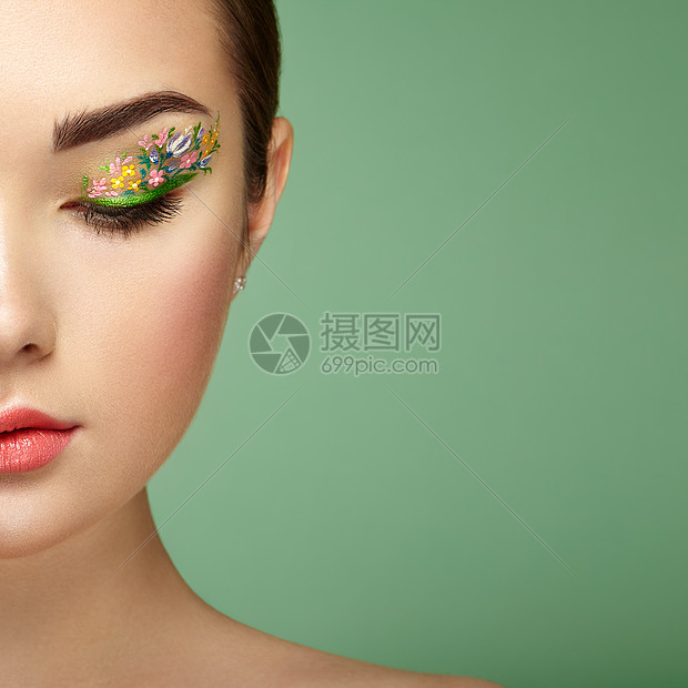 轻漂亮的女人,花妆的眼睛春妆美容时尚睫毛化妆品眼影化妆细节绿色背景的女孩图片
