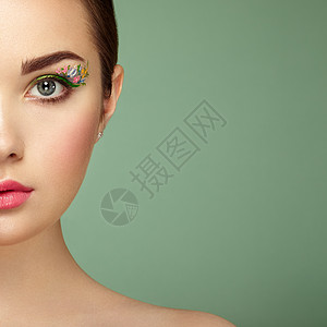 人体艺术轻漂亮的女人,花妆的眼睛春妆美容时尚睫毛化妆品眼影化妆细节绿色背景的女孩背景