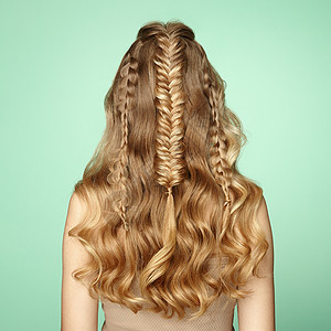 头又长又亮的卷发的金发女孩漂亮的模特,留着卷曲的发型护理美容美发产品辫子的女士背景图片