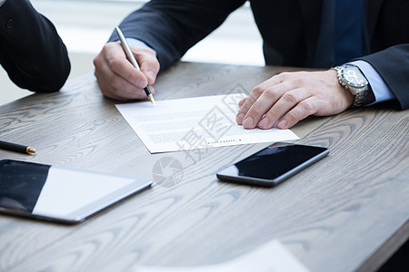 商务人员会议上桌子上签合同商人签订合同背景图片