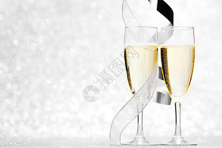 杯香槟银丝带闪闪发光的背景上图片