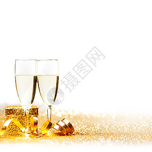 杯香槟装饰的金色丝带隔离白色上图片