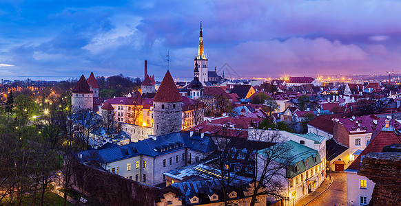 塔林中世纪古镇的全景与奥拉夫教堂塔林城墙照亮黄昏,爱沙尼亚塔林中世纪古镇全景,爱沙尼亚图片
