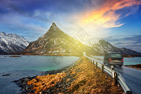 汽车挪威峡湾的道路上日落挪威洛福腾群岛运动模糊挪威路上的车图片
