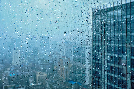 雨水滴窗户璃纹理上,背景摩天大楼雨点落窗户上图片