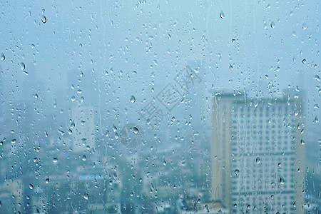 雨水滴窗户璃纹理上,背景摩天大楼雨点落窗户上图片